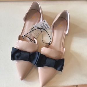 Pointy beige flats with bow.